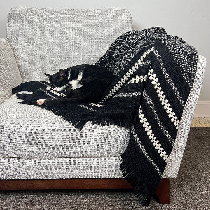 Black alpaca throw blanket with a heathered grey weave and cream stripes