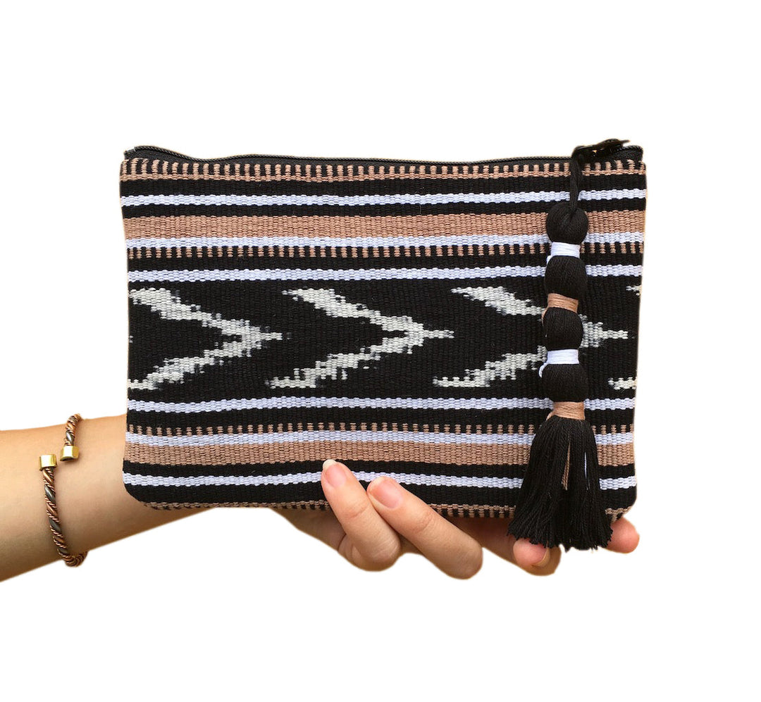 Indigo and tan ikat backstrap clutch with woven fabric and a compact design.