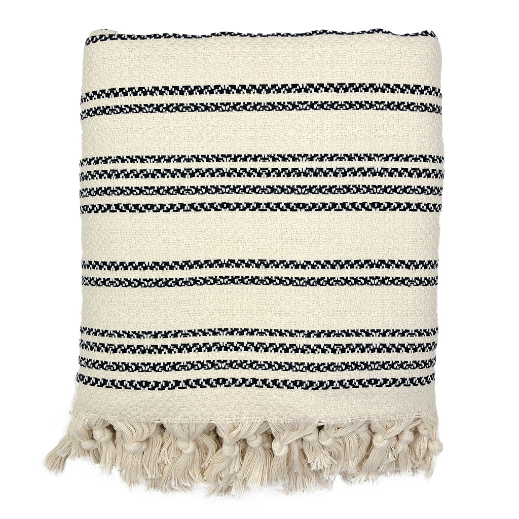 Woven stripe Turkish throw in beige, ivory, and sand on soft fabric.