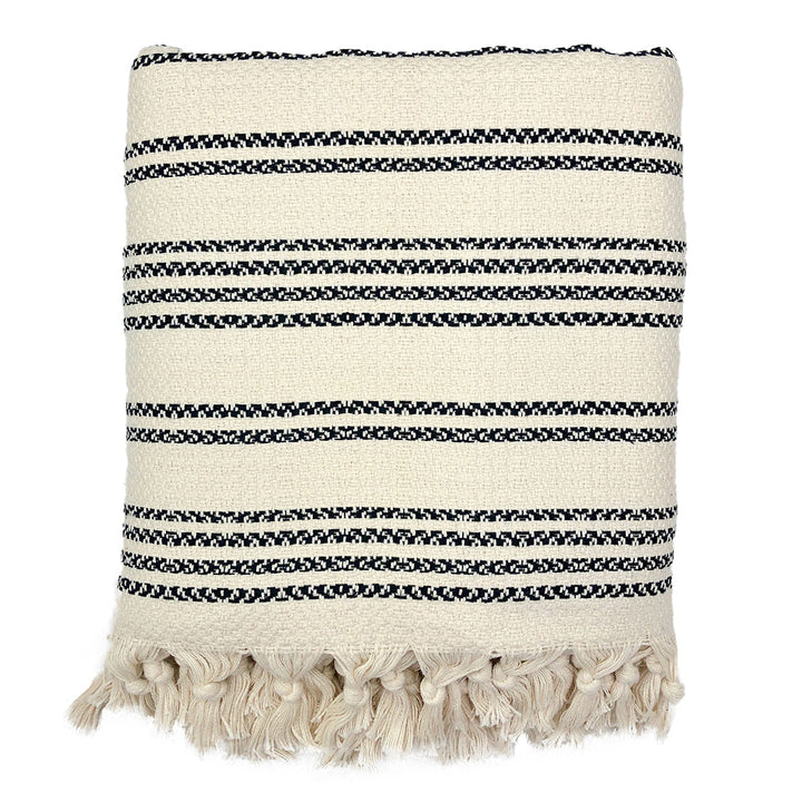 Woven stripe Turkish throw in beige, ivory, and sand on soft fabric.