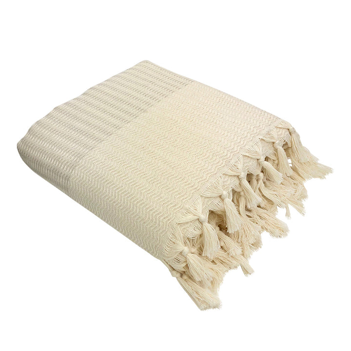 Soft plush wavy Turkish throw blanket in sandy beige, draped on a couch.