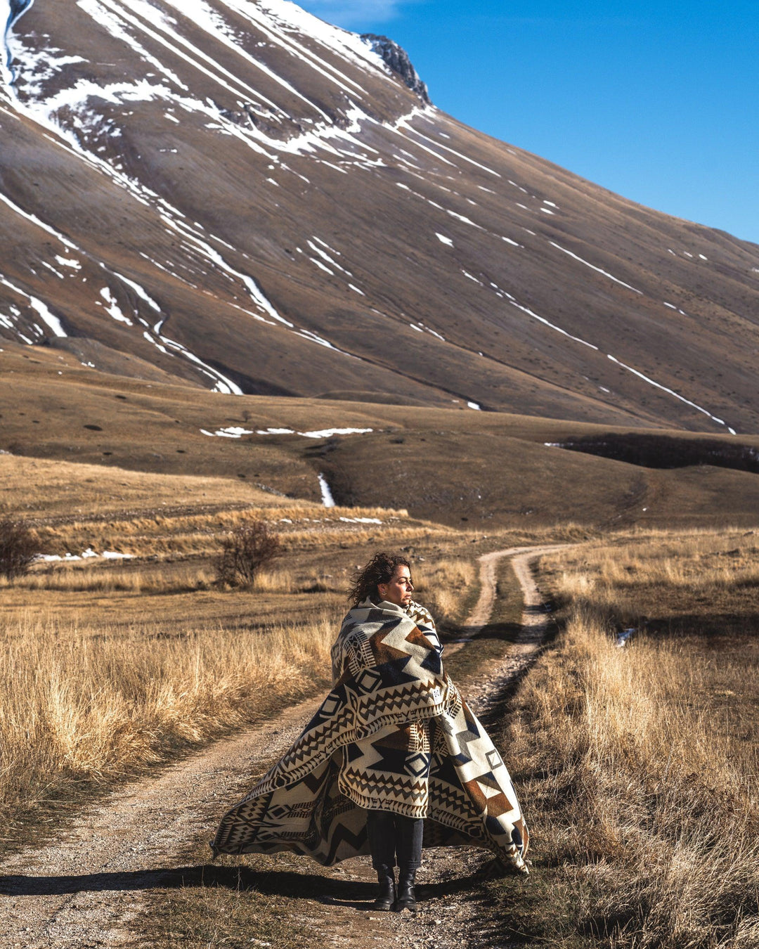Earth Awa blanket showing the navy triangle and stepped-diamond weave with a bound edge.