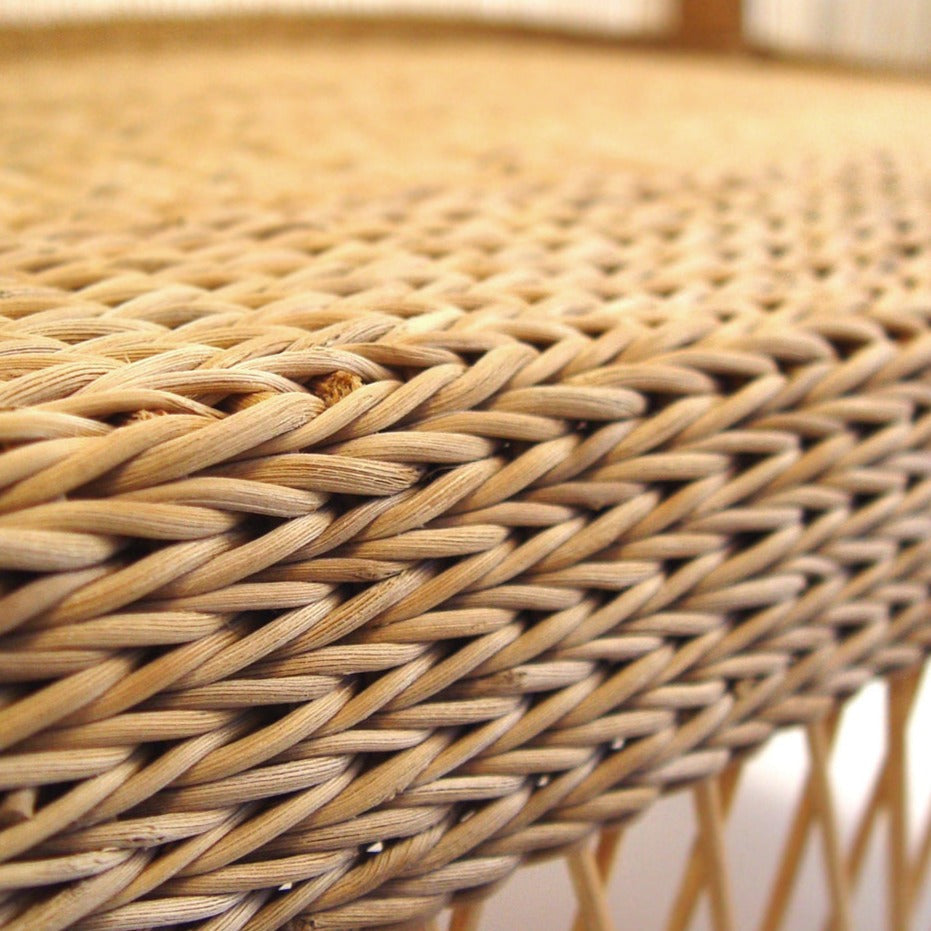Malawi cane chair with woven cane seat and armrests on a sturdy wooden frame.