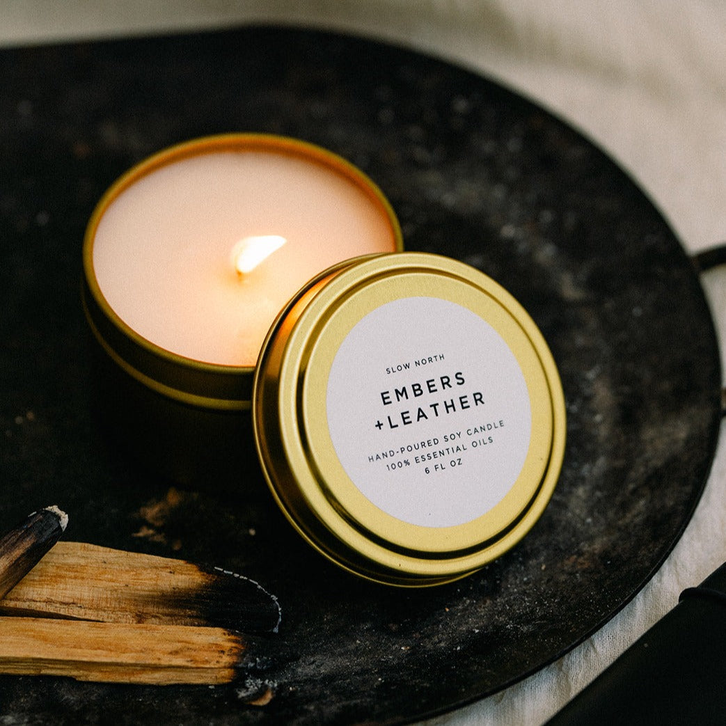 6 oz Embers &amp; Leather travel tin candle with warm ember and leather-inspired scent.