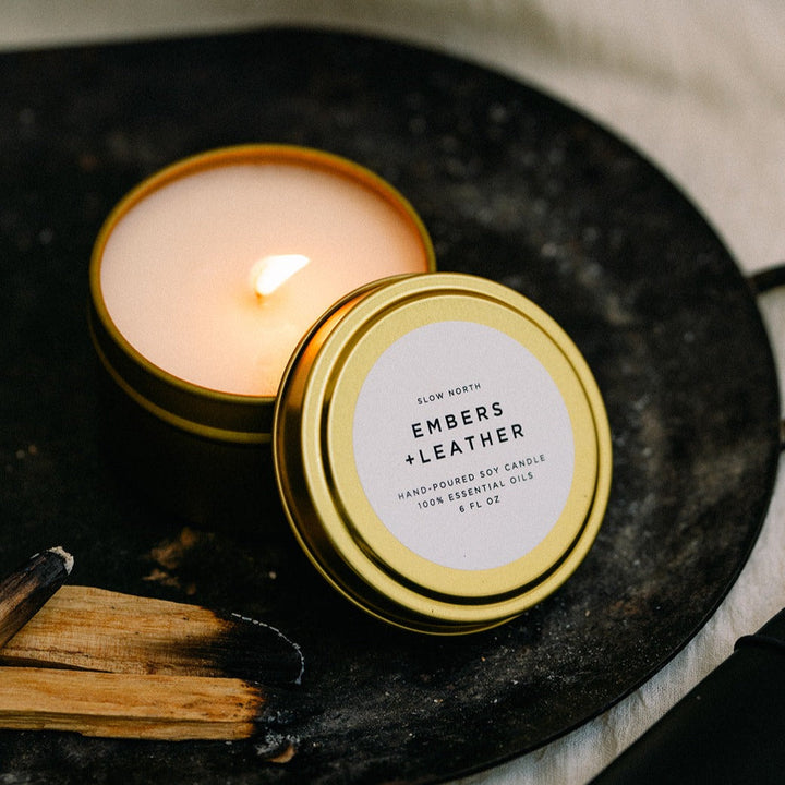 6 oz Embers &amp; Leather travel tin candle with warm ember and leather-inspired scent.