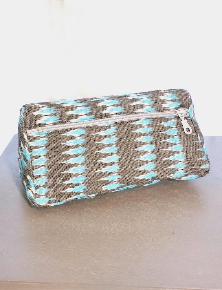 Grey and teal ikat cotton toiletry bag with a zip closure.