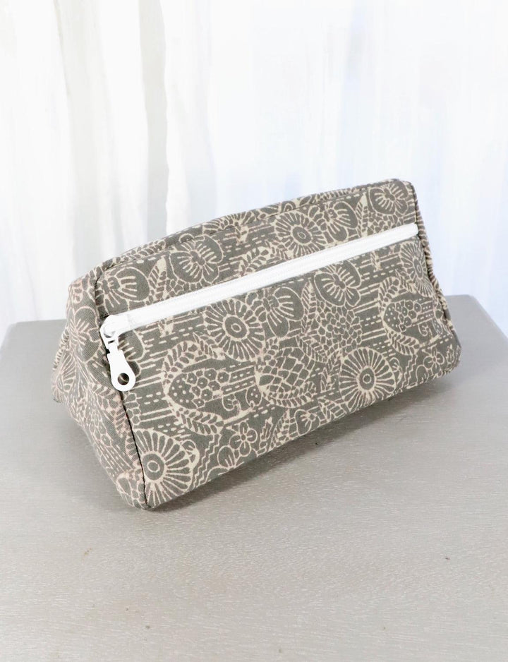Grey cotton toiletry bag with a triangle or floral pattern.