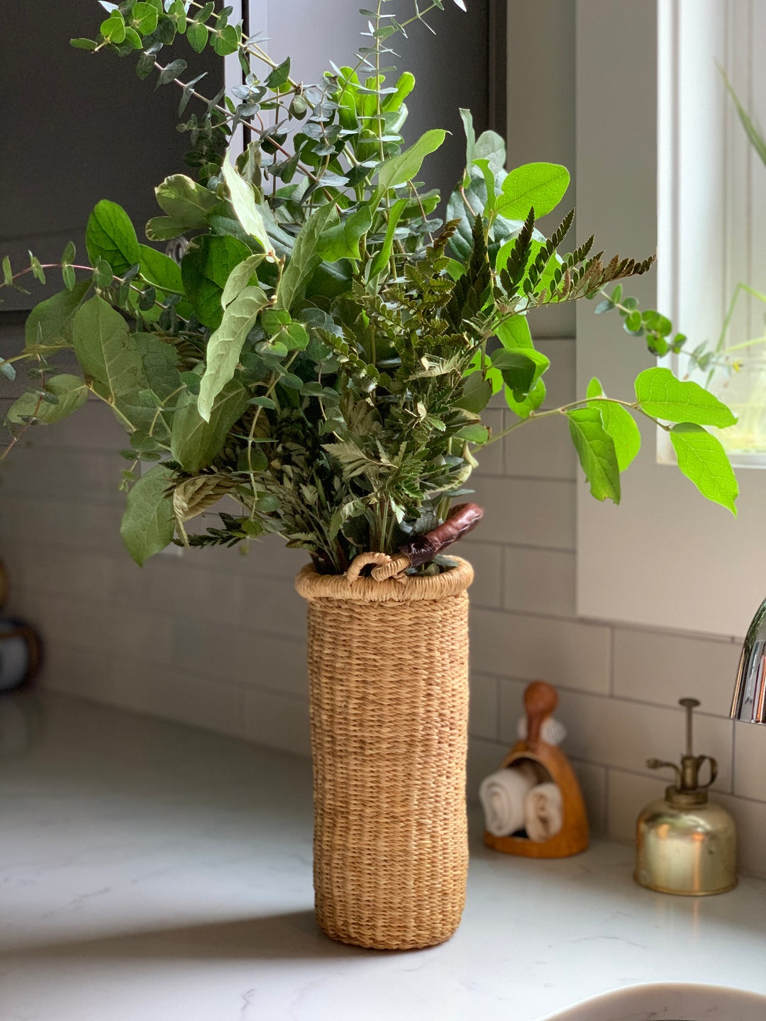 Handwoven straw Astoria vase that doubles as a single-bottle wine holder, with a leather handle.