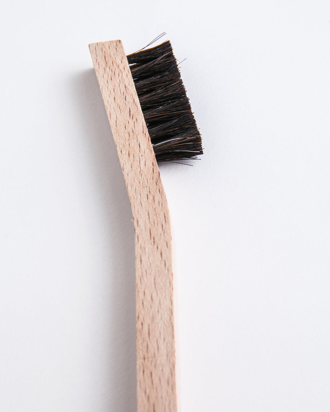 Small detail brush with natural bristles and a compact handle for cleaning tight spaces.