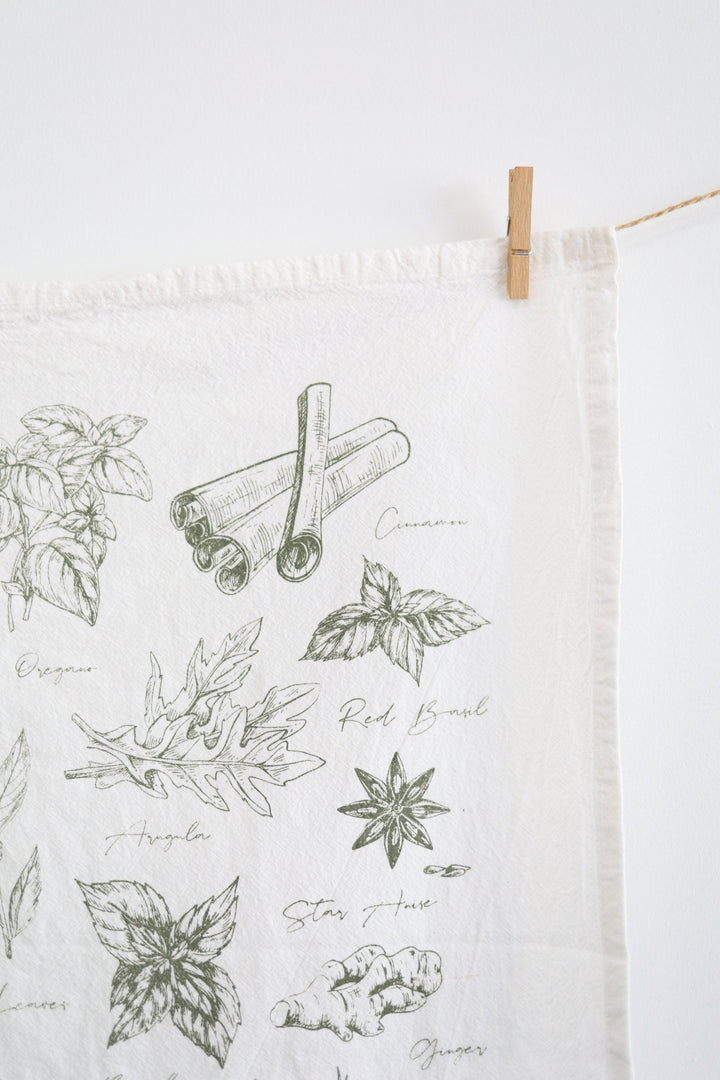 Cotton tea towel with watercolor green herb illustrations.