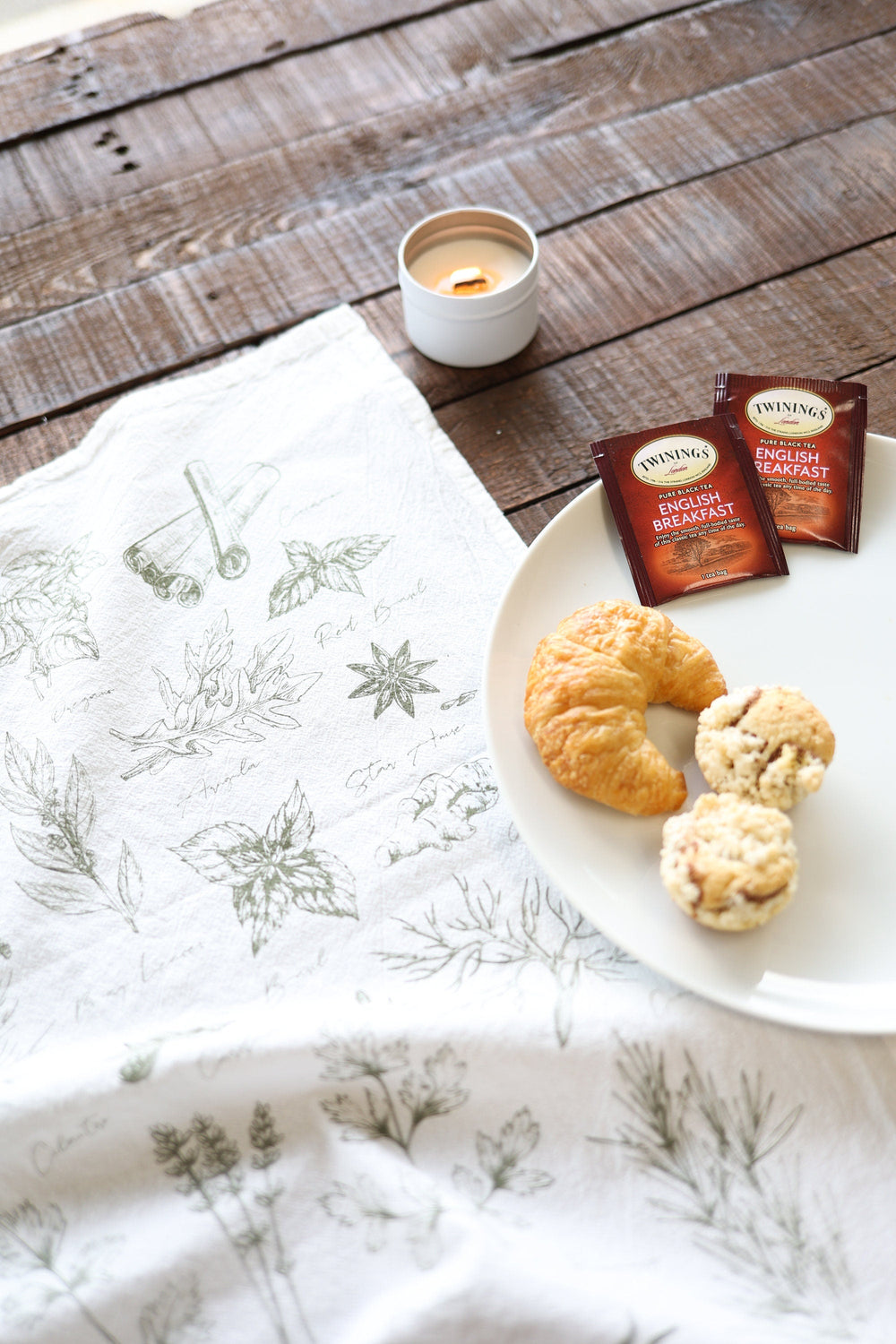Cotton kitchen tea towel printed with watercolor herb illustrations.