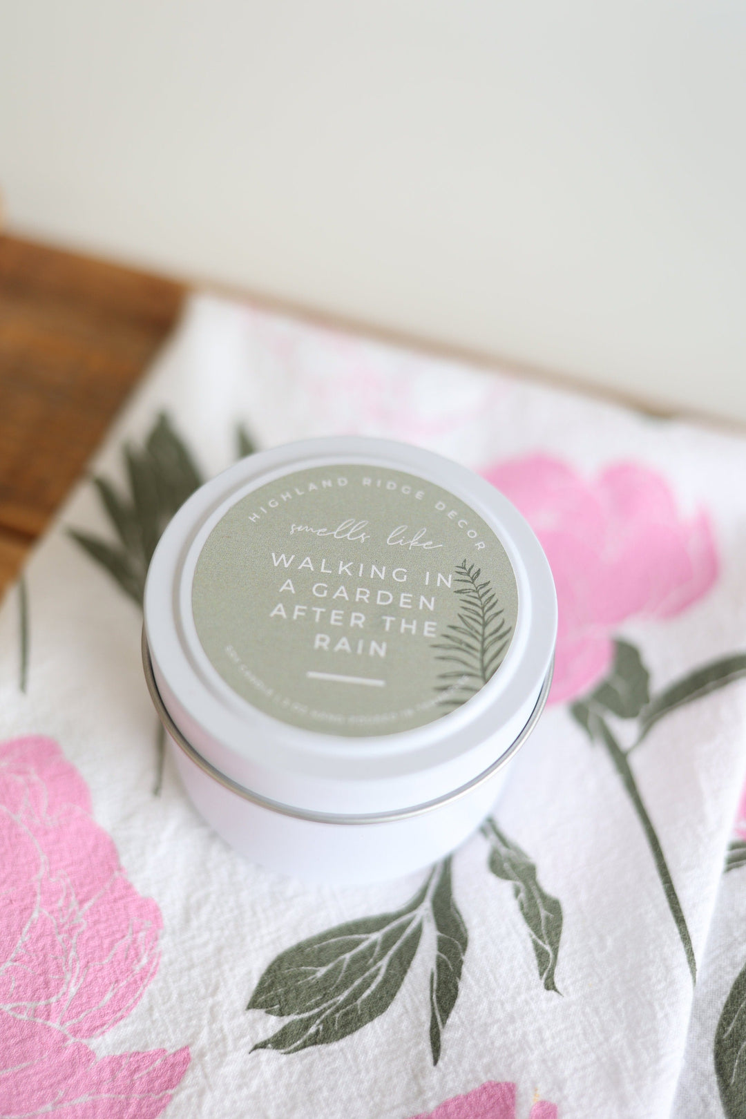 Hand-poured soy Garden Rain candle in a tin with a botanical label.