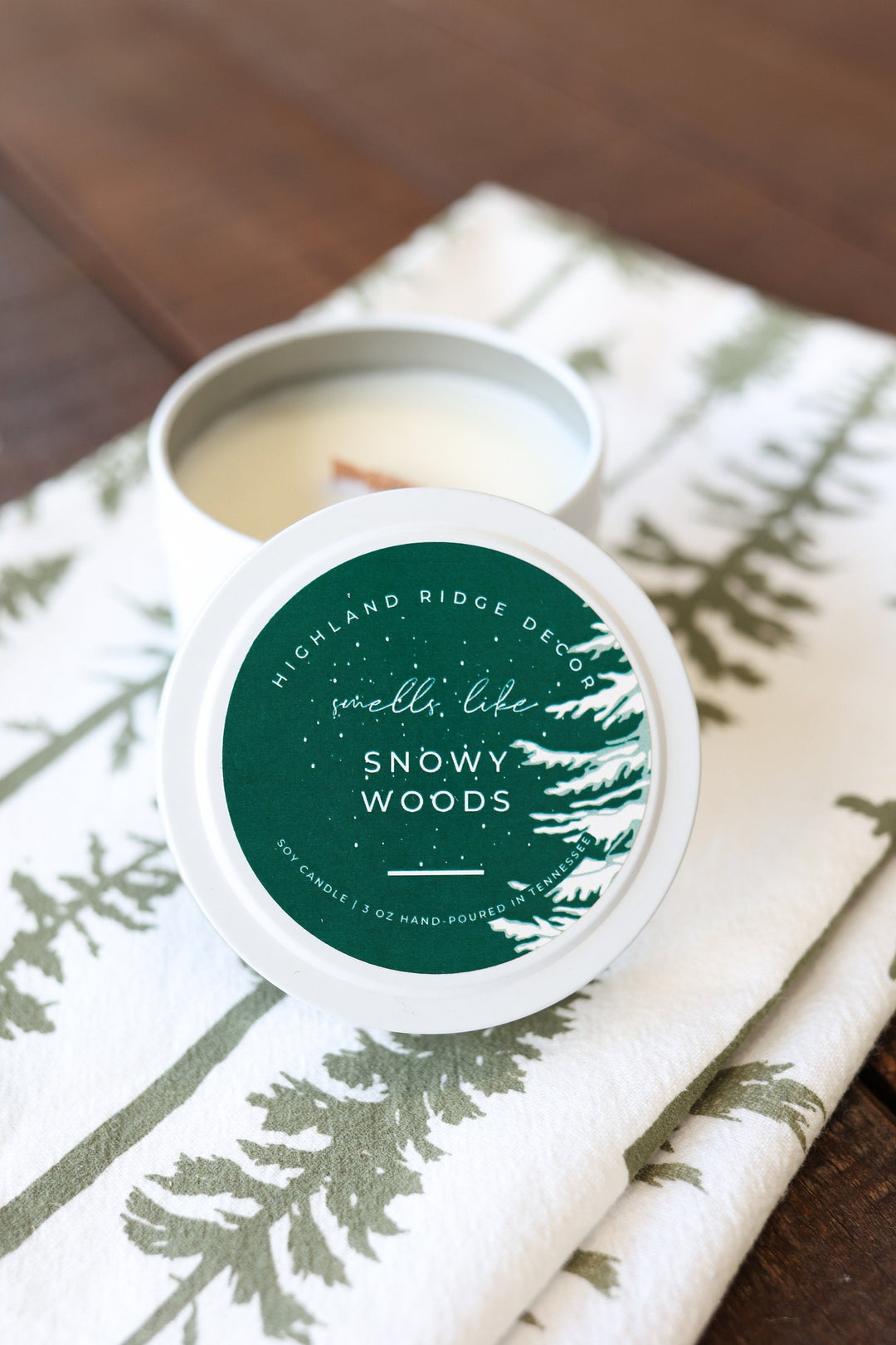 Snowy Woods soy candle in a tin with a winter forest label.
