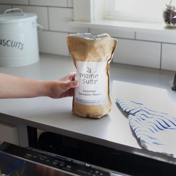 Natural, PVA-free dishwasher powder in a resealable bag with a scoop.