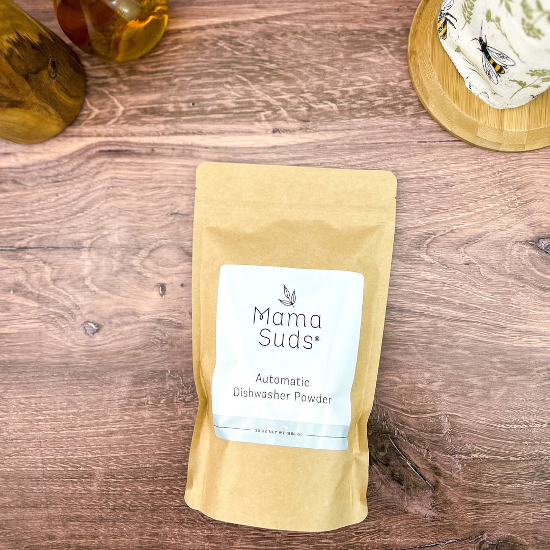 Natural, PVA-free dishwasher powder in a clear container with a scoop.
