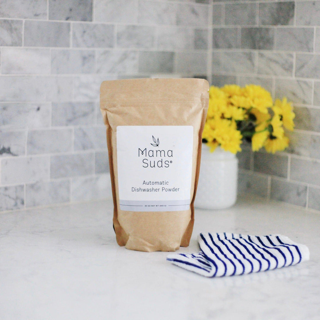 Natural, PVA-free dishwasher powder in a clear container with a scoop.