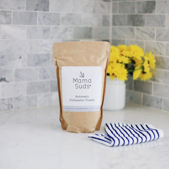 Natural, PVA-free dishwasher powder in a clear container with a scoop.