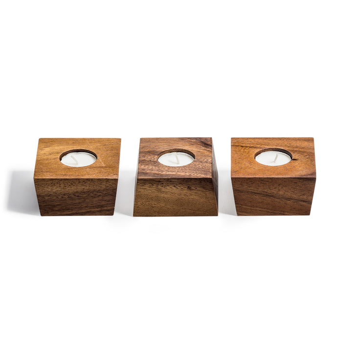 Set of three acacia wood tealight holders with a natural wood finish.
