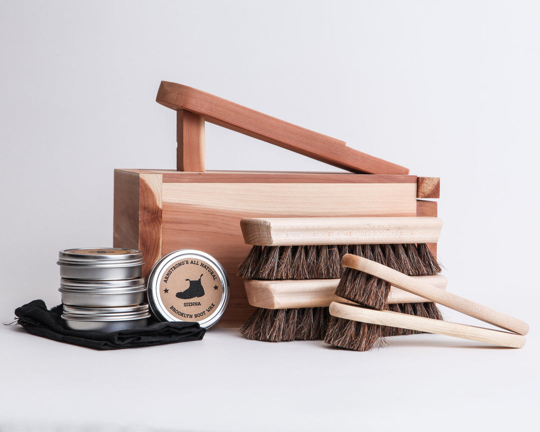 Shoe Shine Box kit with brushes, wax, and cloths for caring for leather shoes.