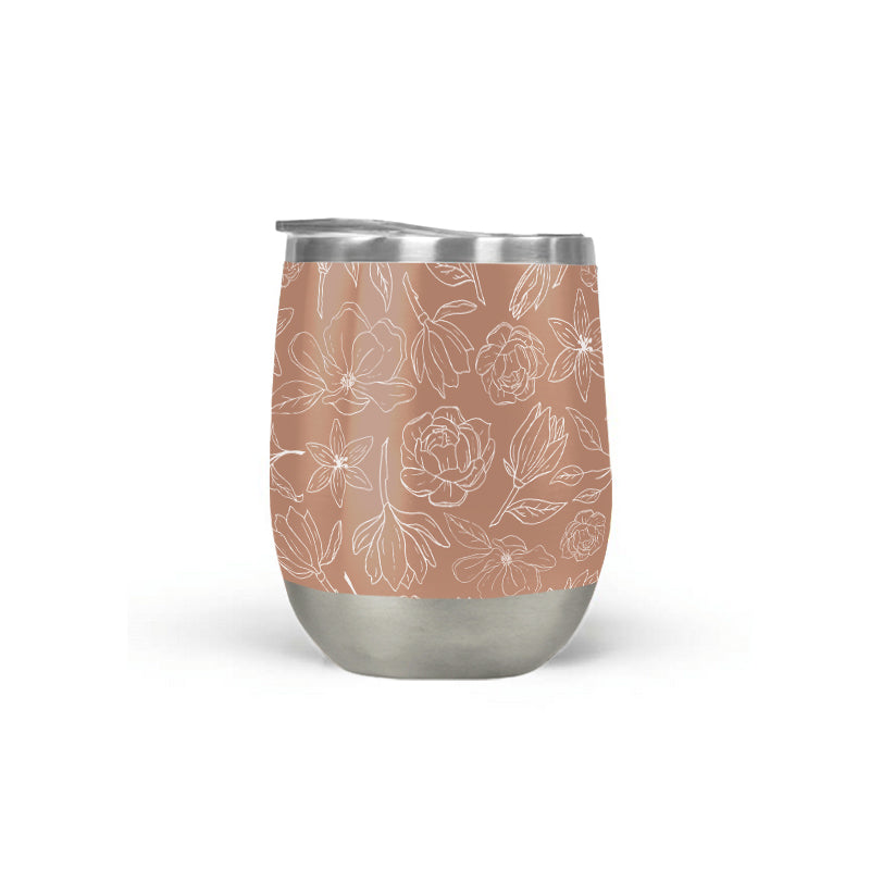 Copper Magnolia insulated wine tumbler with white line-art florals on a terracotta body and stainless steel base.