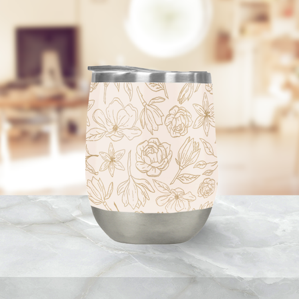 Gold magnolia insulated wine tumbler with a gold floral design on a stainless steel cup.