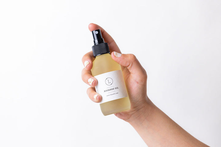 Eucalyptus massage oil in a glass bottle with eucalyptus leaves.