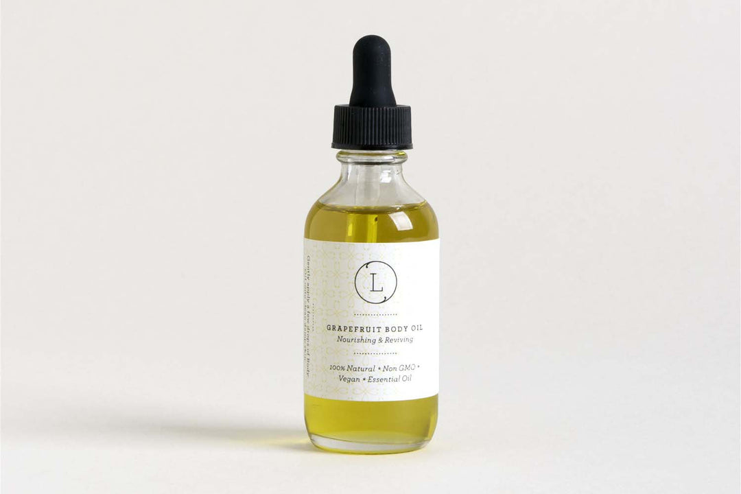 Lizush grapefruit body oil in a clear glass bottle, a moisturizing body oil.