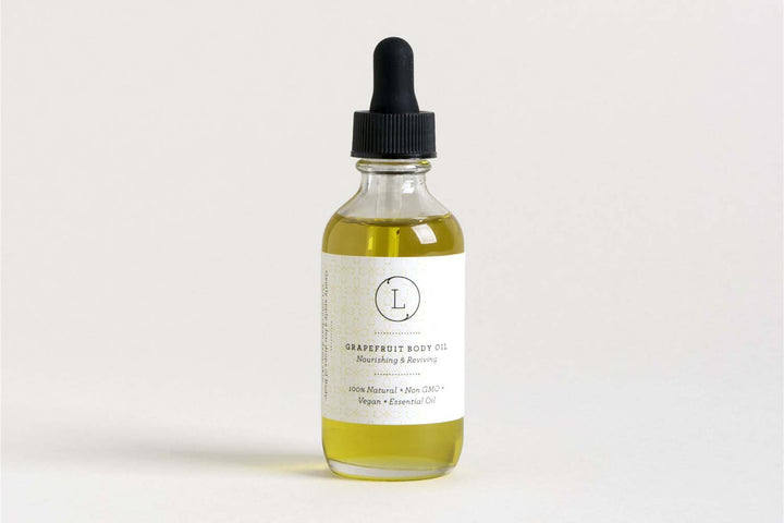 Lizush grapefruit body oil in a clear glass bottle, a moisturizing body oil.