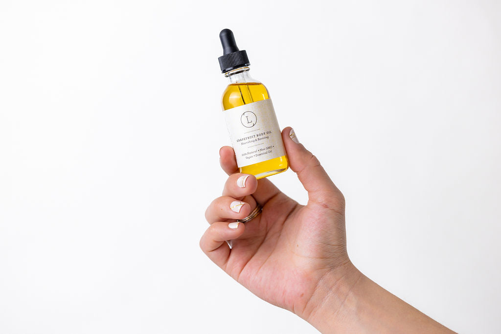 Grapefruit body oil in a clear glass bottle with a natural citrus scent.