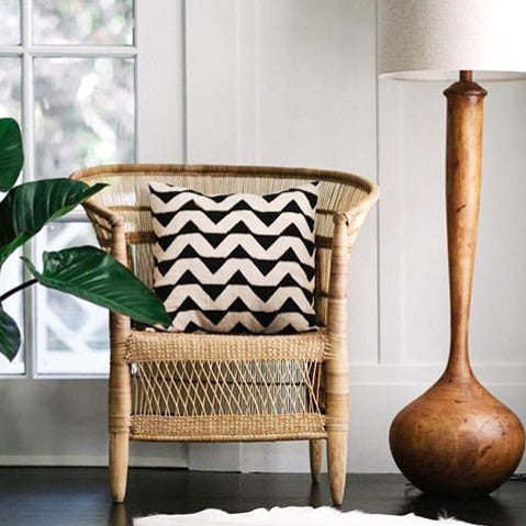 Malawi cane chair in natural finish with a woven cane seat and back and wooden legs.