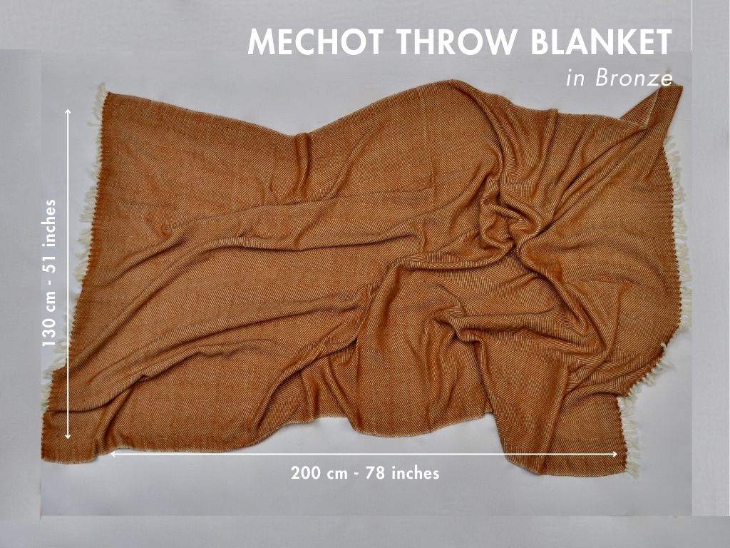 Bronze herringbone cotton throw laid flat with measurements: 130 by 200 cm, 51 by 78 inches.