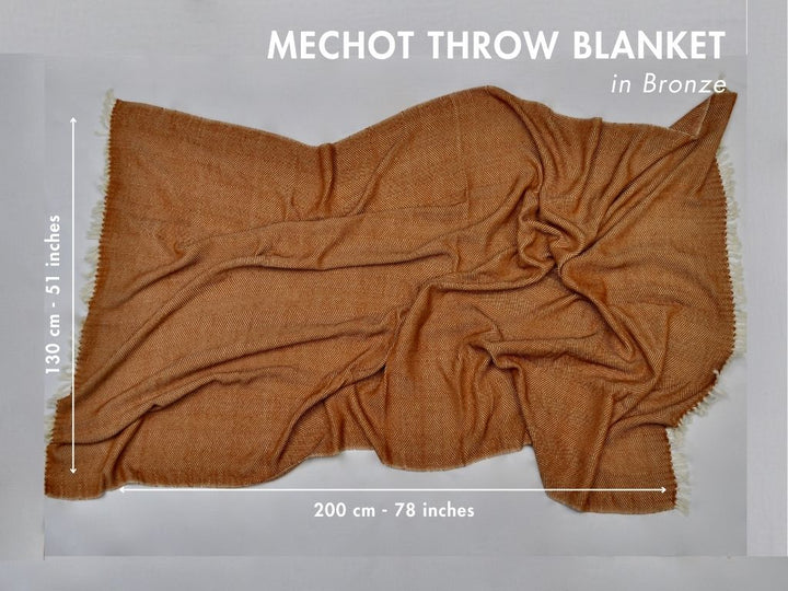 Bronze herringbone cotton throw laid flat with measurements: 130 by 200 cm, 51 by 78 inches.