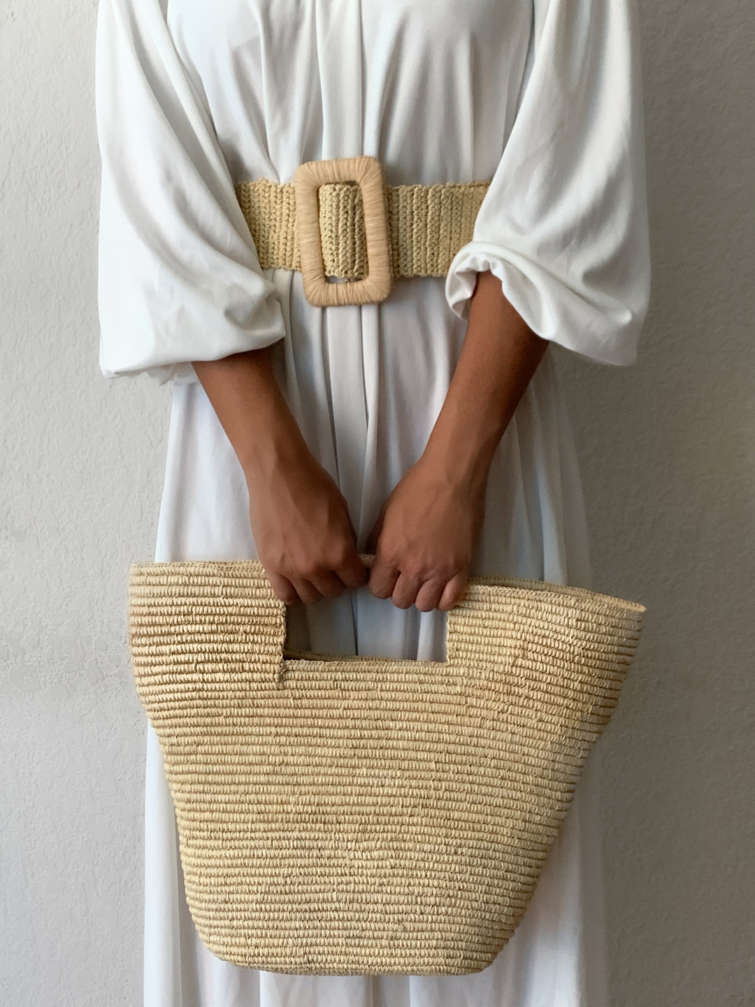 Brown woven straw belt with a woven design, for casual warm-weather looks.