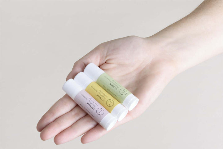 Lizush natural lip balm set, three unscented lip balms in a clear container.