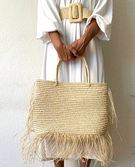 Handwoven crochet fringe tote bag with fringe detail and natural fiber texture.