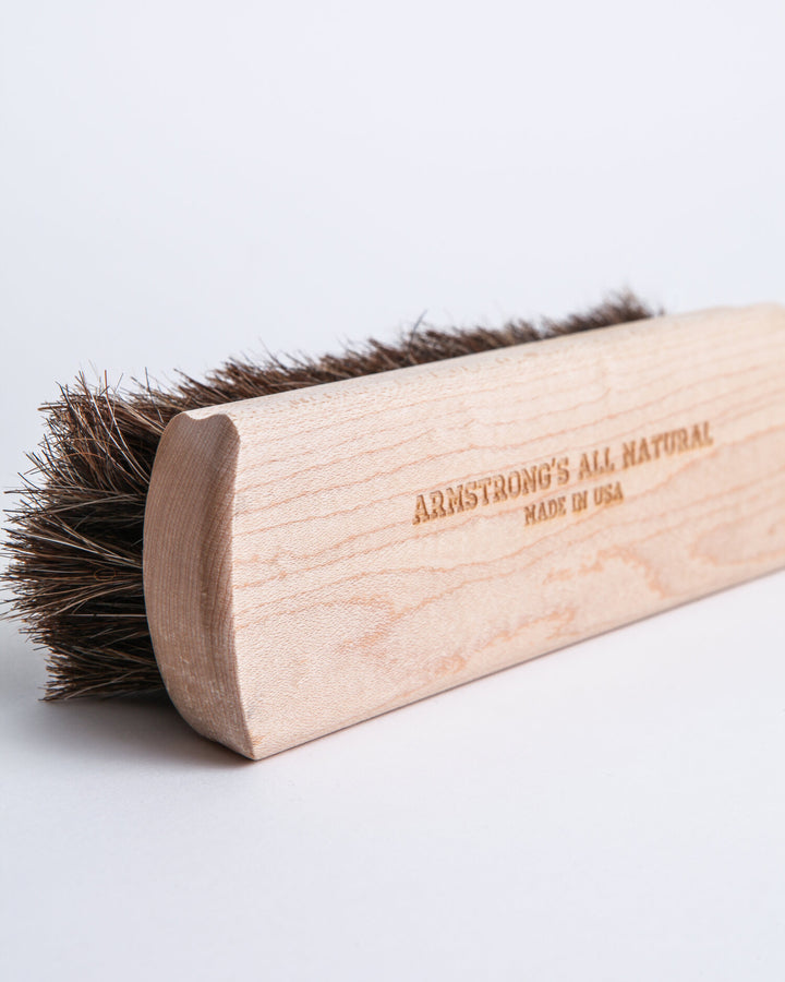 Handcrafted horsehair buffing brush with a wooden handle for shining leather.