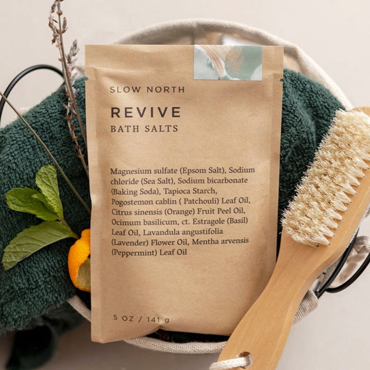 Revive bath salts shown in biodegradable kraft pouch with colorful mineral crystals.
