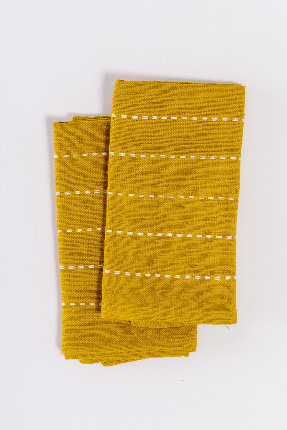 Pair of gold handwoven cotton cocktail napkins, folded