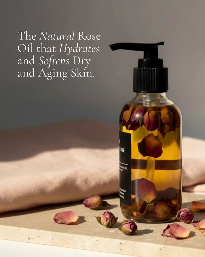 Organic rose body oil in a glass bottle with a dropper and fresh roses.