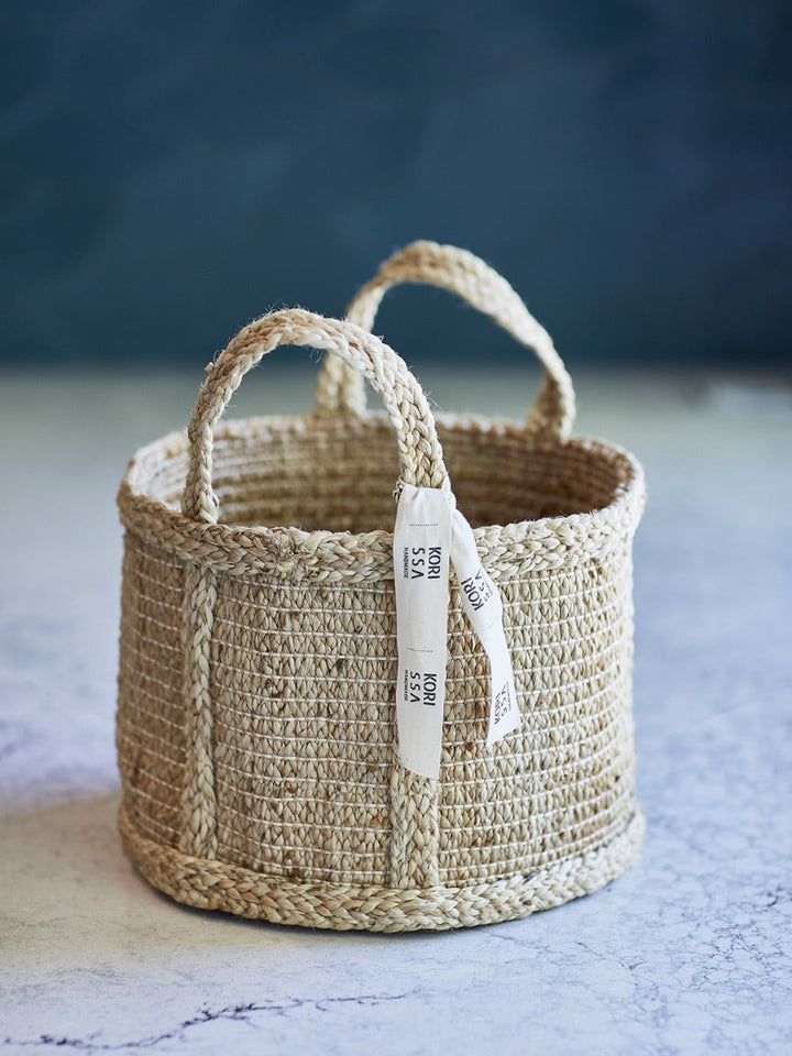 Natural jute basket from DC-KORISSA, showcasing a woven eco-friendly storage container with sturdy handles.