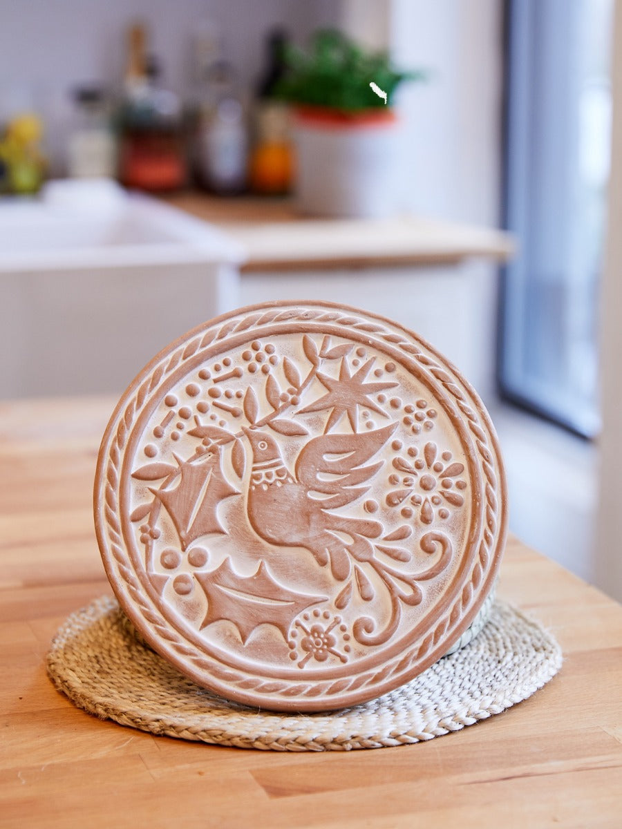 Round bird bread warmer basket with warm bread in a table setting