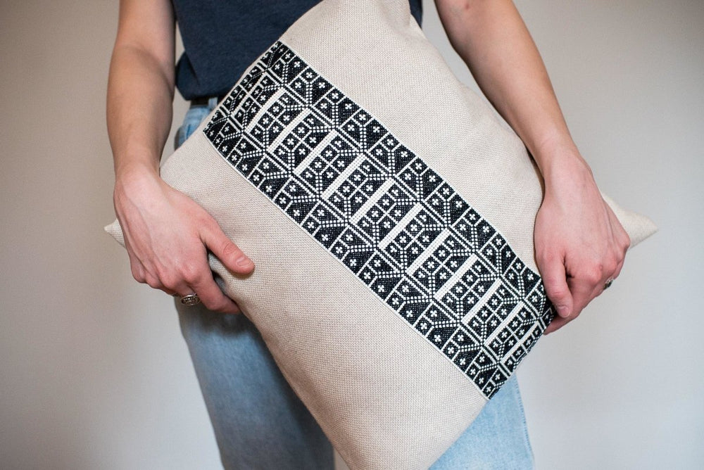 Hand-embroidered cushion cover, black-and-ivory Carnation cross-stitch on natural cotton.