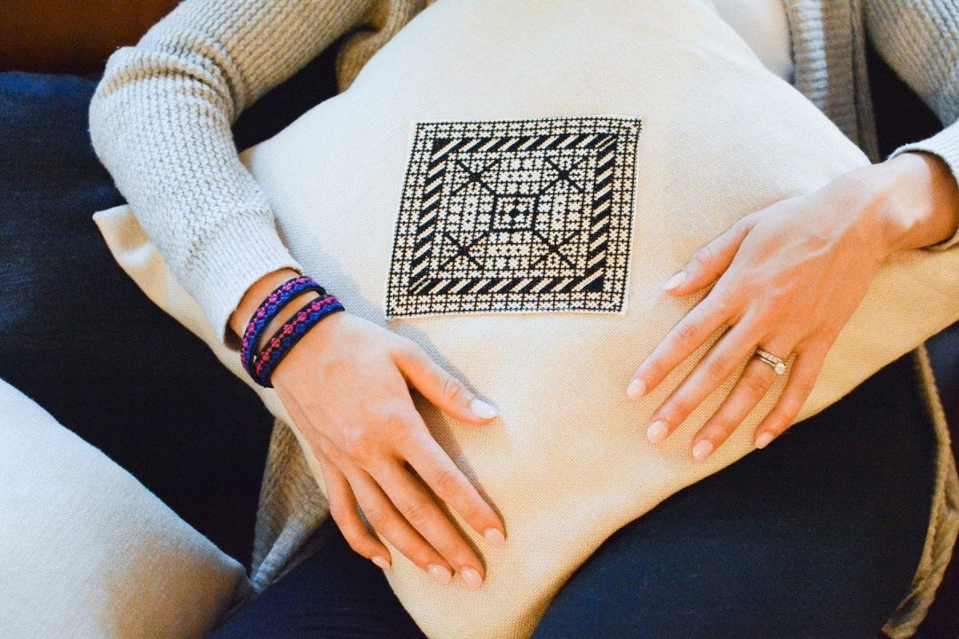 Natural oatmeal pillow cover with a central black-and-white Diamond tatreez medallion.