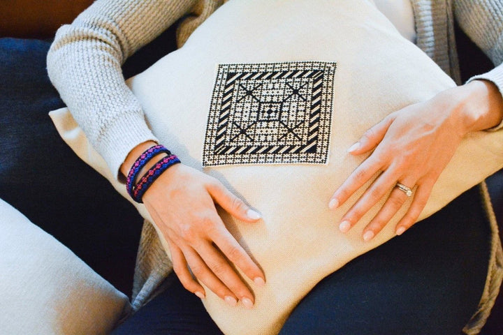Natural oatmeal pillow cover with a central black-and-white Diamond tatreez medallion.