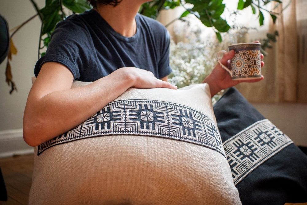 Hand-embroidered cushion cover, black-and-ivory Moon with Feathers cross-stitch on natural cotton.