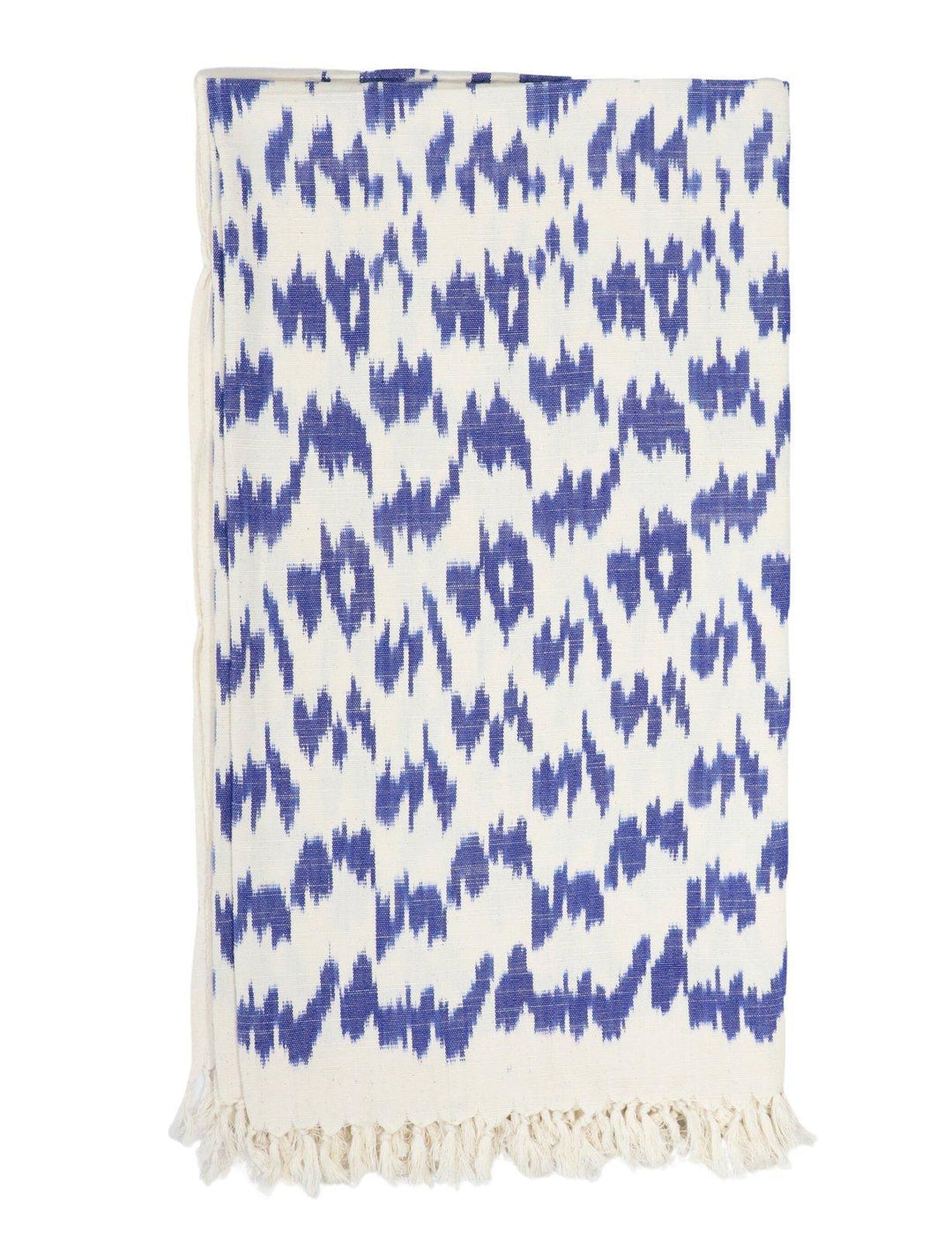Handwoven cotton throw in a blue ikat pattern on an off-white base.