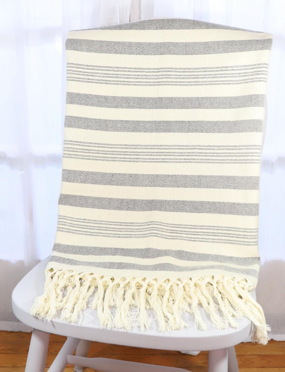 Handwoven cotton throw with charcoal stripes, textured fabric.