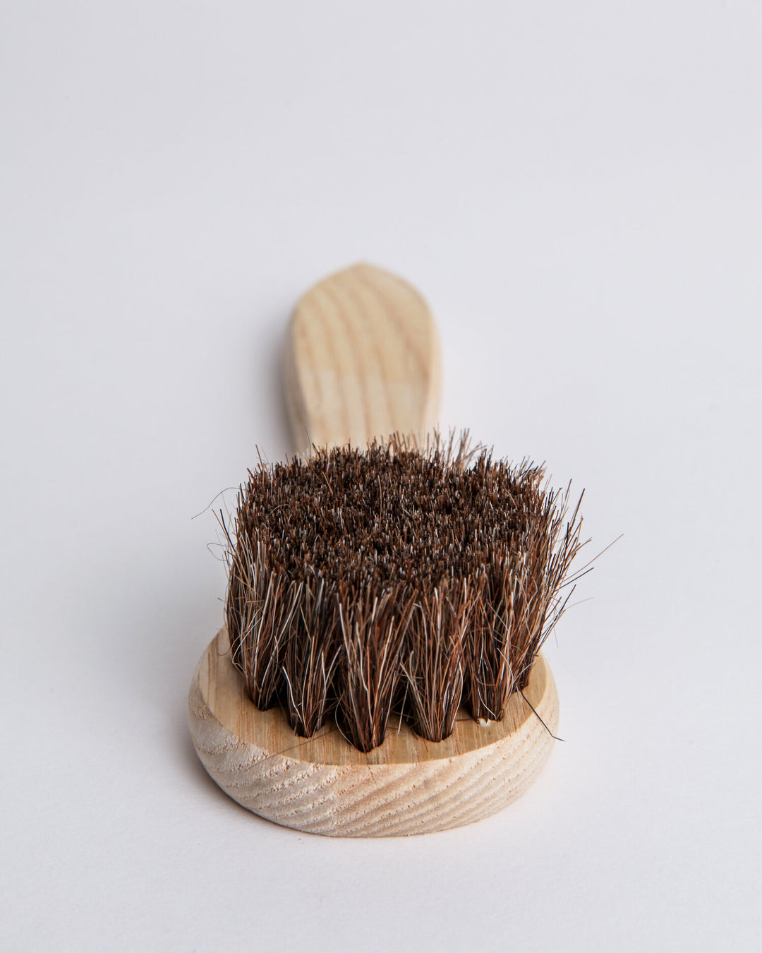 Natural horsehair dauber with a wood handle for applying polish and conditioner to leather.