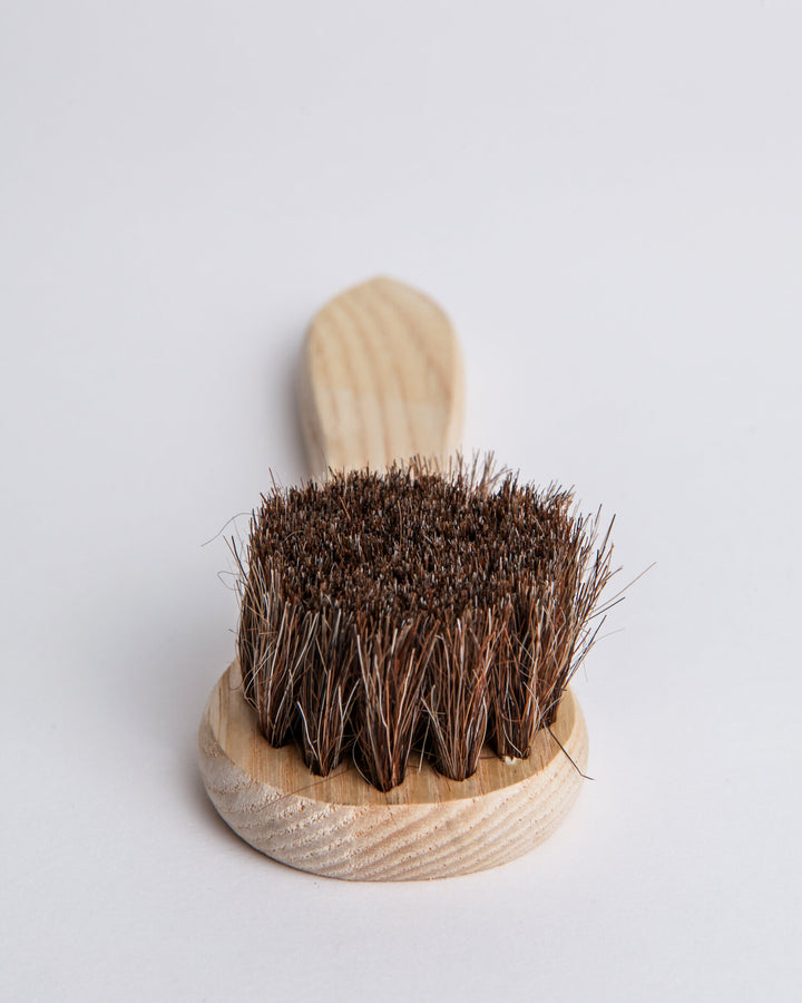 Natural horsehair dauber with a wood handle for applying polish and conditioner to leather.
