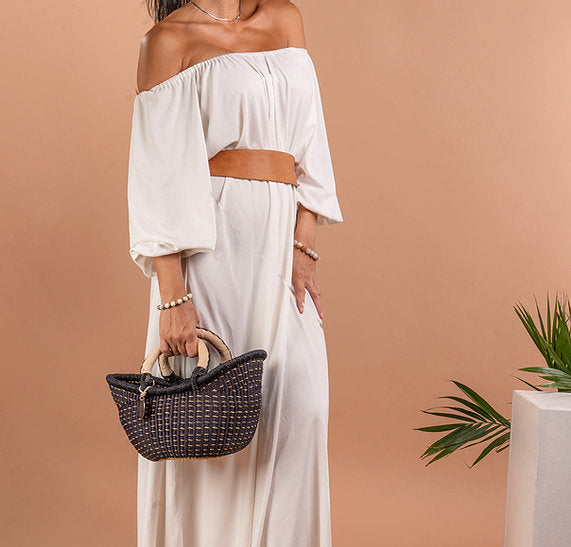 The Petite Victoria handwoven straw basket bag with a leather handle.